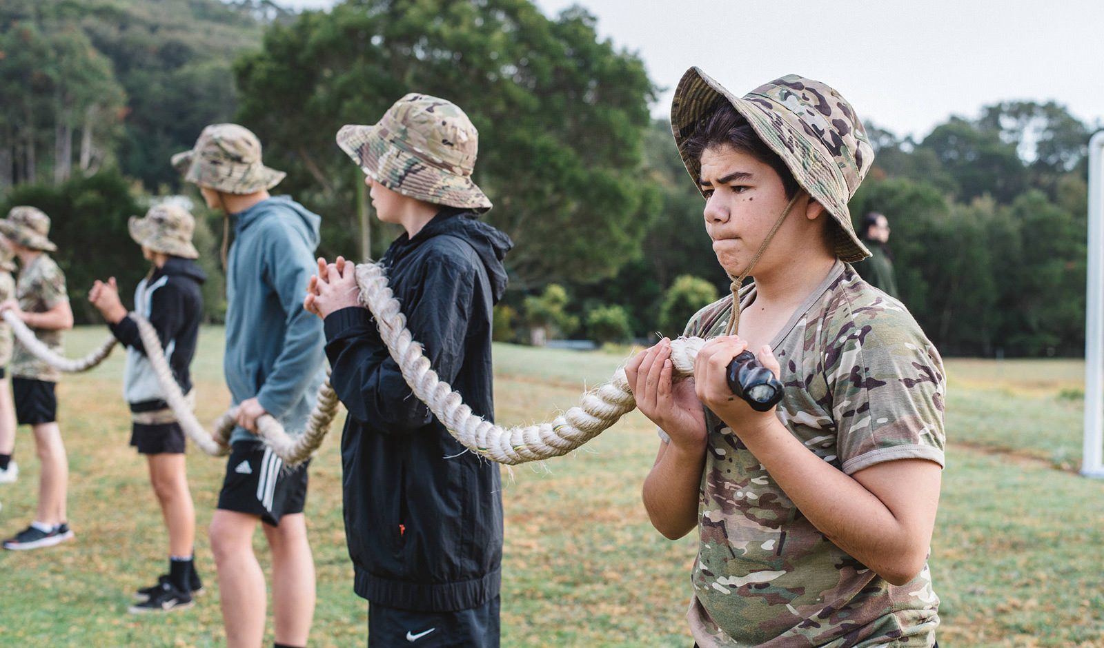 An image of boys holding up a rope to build teamwork