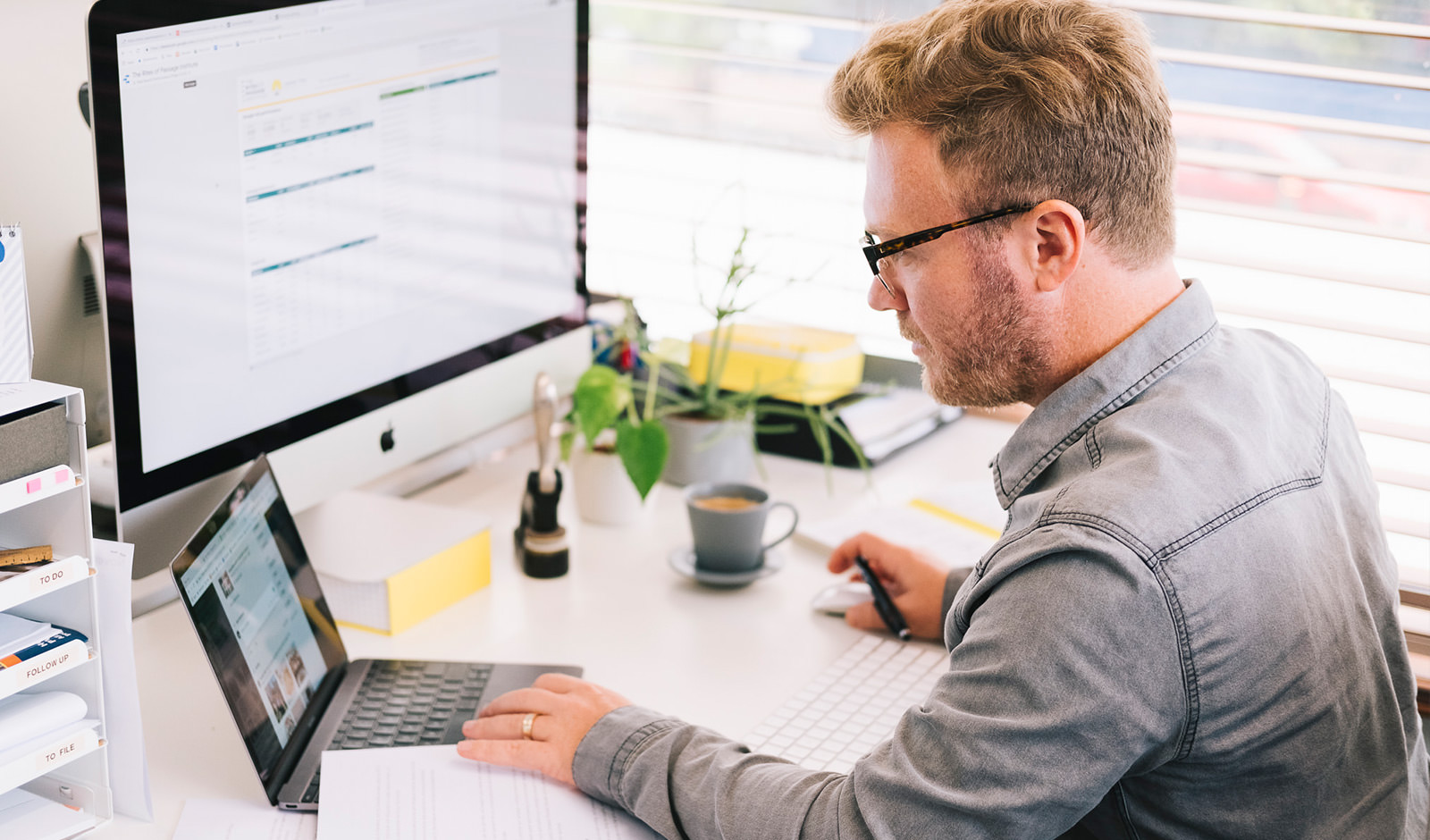 A man assessing marketing success on two computers