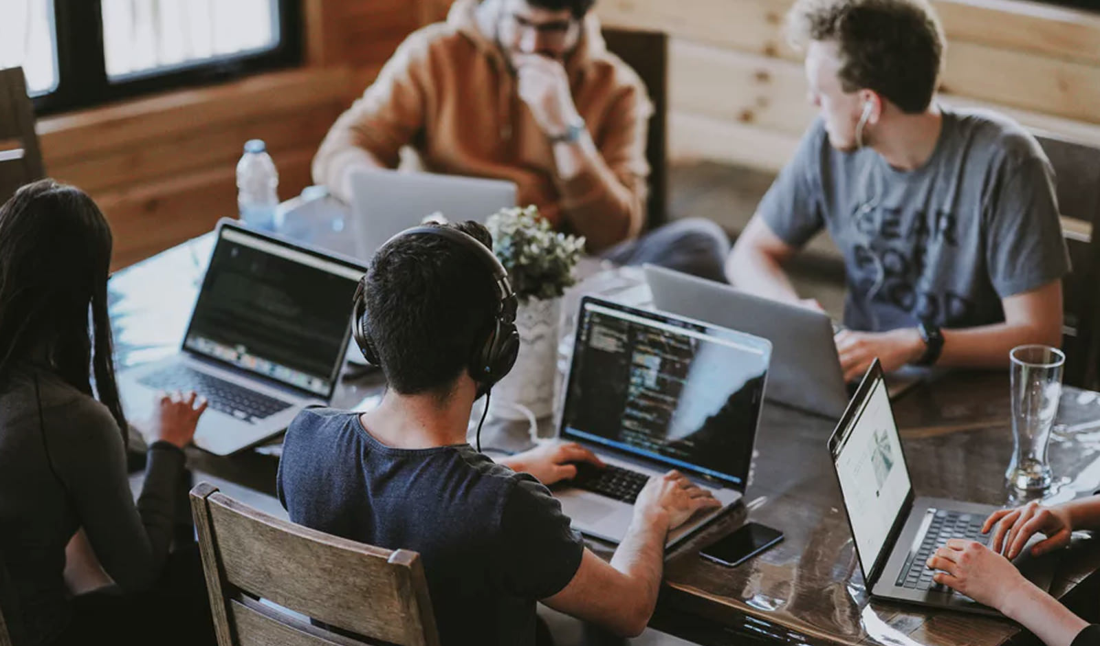 An image of people wokring at a shared table on computers