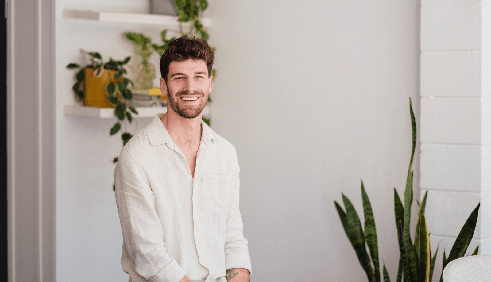 Lemon Tree's Graphic Designer Frank sitting on a stool smiling at the camera.