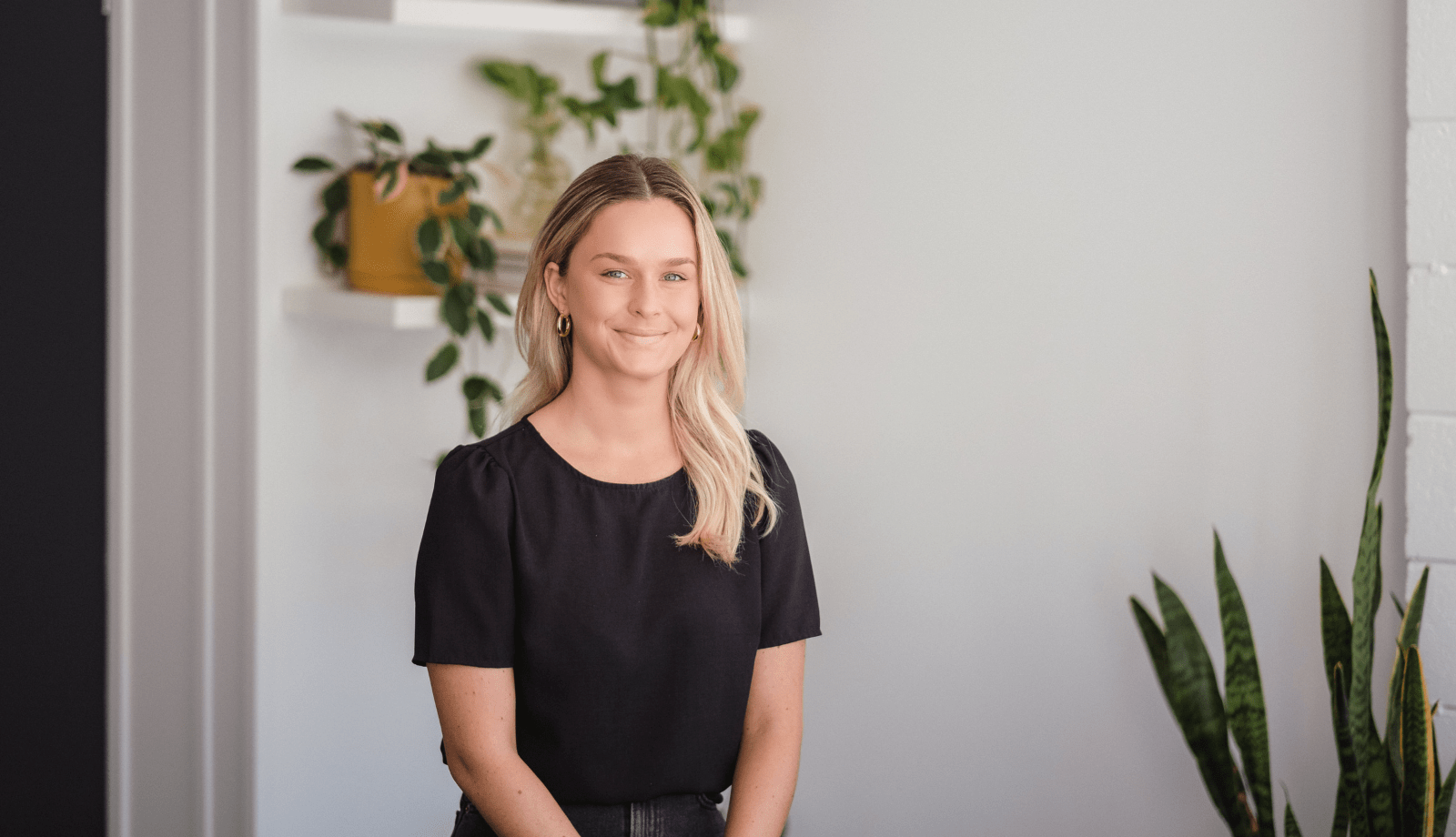 Steph, lemon tree marketing's content & design coordinator. White woman with long blonde hair sits in front of bookcase.