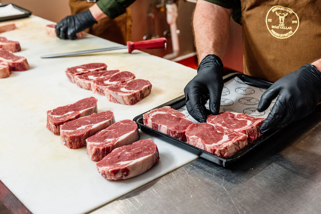Butcher arranging cuts on a tray